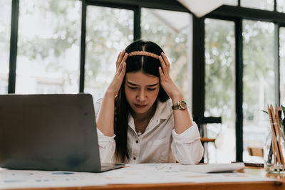 Young woman using laptop at table