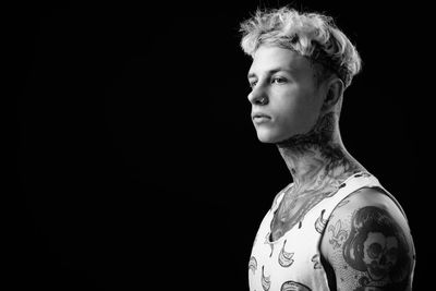 Portrait of shirtless man against black background