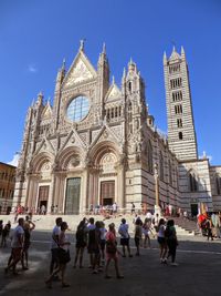 Group of people in front of cathedral against sky