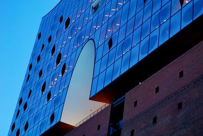 Low angle view of modern building against blue sky