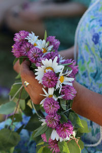 Midsection of woman holding flowers