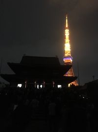 Illuminated tower against sky at night