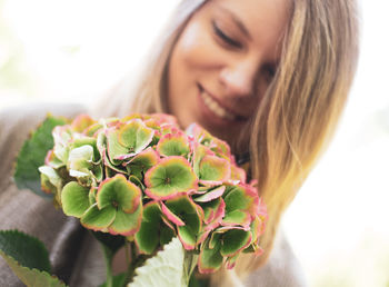 Close-up of smiling woman holding plant