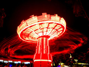 Low angle view of illuminated ferris wheel against sky at night