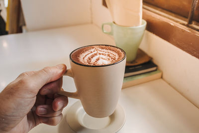 Midsection of person holding coffee cup