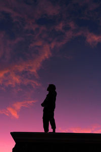 Silhouette man standing against orange sky