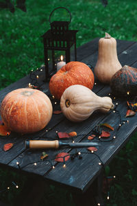 Halloween decorations pumpkins on wooden table outdoors.