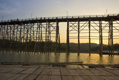 Low angle view of footbridge against sky during sunset