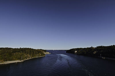 Scenic view of river against clear blue sky