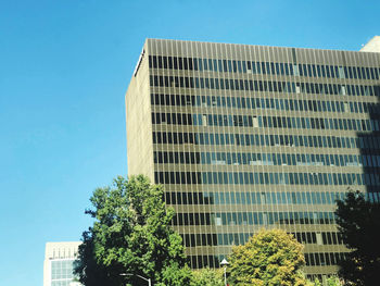 Low angle view of modern building against clear blue sky