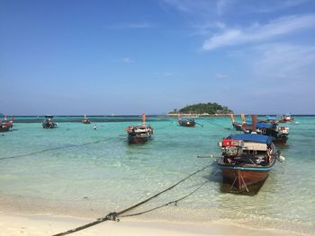 Boats moored on sea against sky