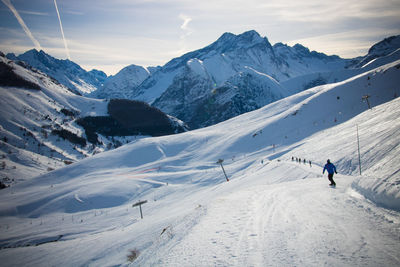 Person skiing on snow covered mountain against sky