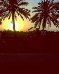 Silhouette palm trees against sky during sunset