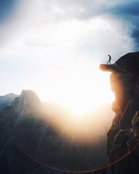 Sun shining through clouds over mountain