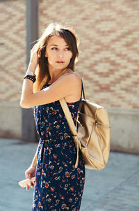 Beautiful woman looking away while standing on street