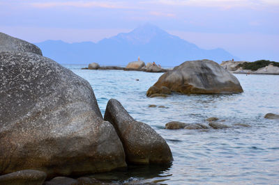 Rock formation in sea against sky