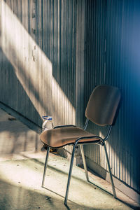 Empty chairs and table against wall