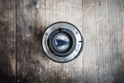 Directly above shot of camera lens on wooden table