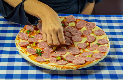 Midsection of man with pizza on table