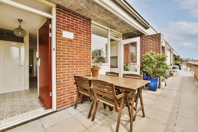 Empty chairs and tables in front of house