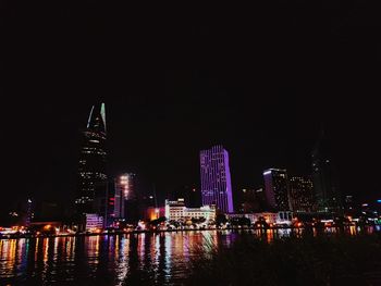 Illuminated buildings in city against sky at night