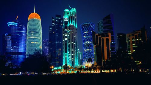 Illuminated buildings against sky at night