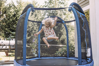 Cheerful girl jumping in trampoline