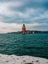 Scenic view of sea by buildings against sky