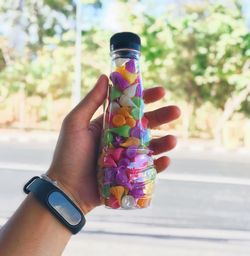 Midsection of person holding multi colored umbrella