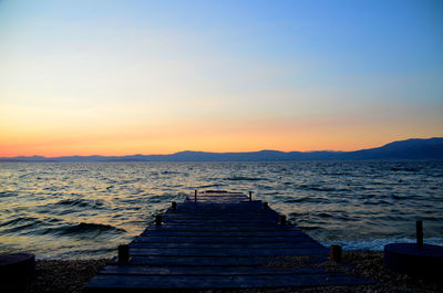 Pier on sea at sunset