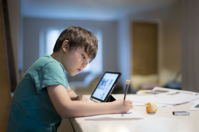 Rear view of boy using mobile phone