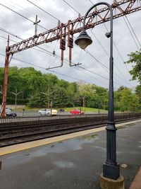 Railroad tracks by road against sky