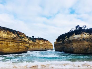 Rock formations by sea against sky