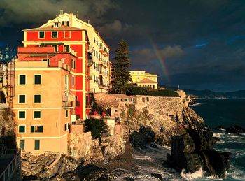 Buildings by sea against sky in city