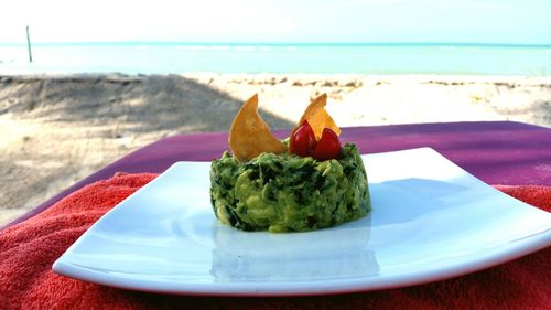 Close-up of food served on beach against sky