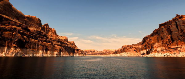 Scenic view of sea by rock formation against sky