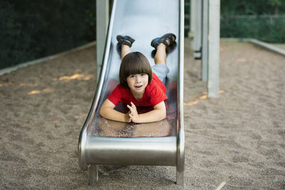 Portrait of young woman sitting in playground
