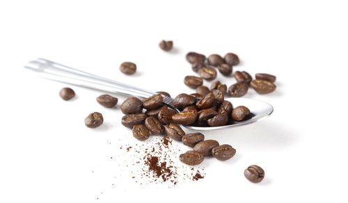 High angle view of coffee beans against white background