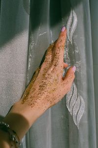 Cropped hand of woman touching glass