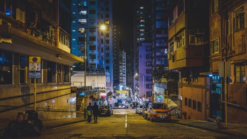 Street amidst buildings in city at night