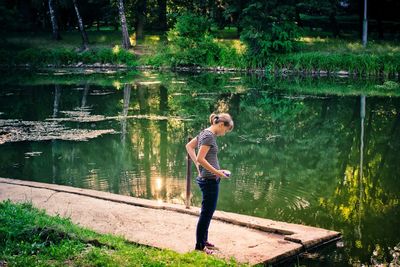 Full length of a young woman by pond