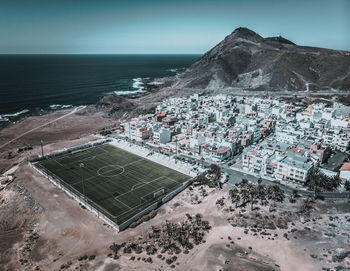High angle view of buildings by sea against sky