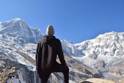 Rear view of man against on snowcapped mountains