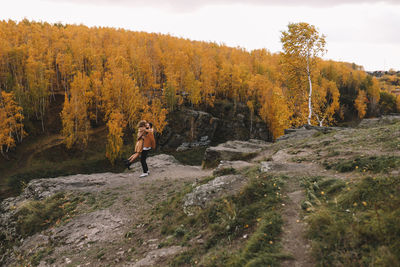 Happy people in love are travel hike in nature in the autumn forest. romantic trip to countryside