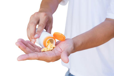 Close-up of man holding hands over white background