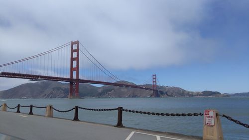 View of suspension bridge against cloudy sky