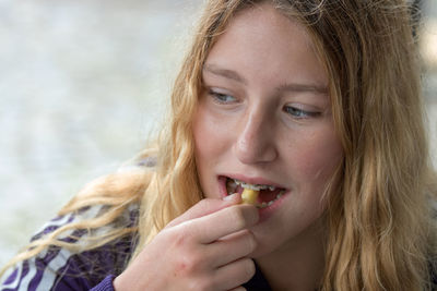 Close-up of young woman eating cashew nut