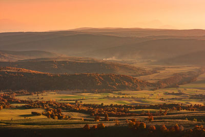 Scenic view of agricultural field against sky during sunset