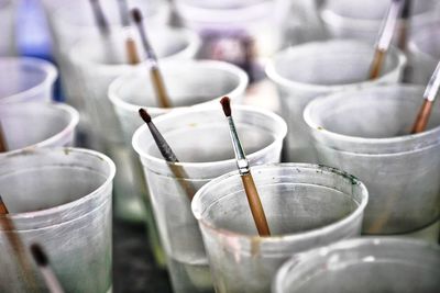 Close-up of paintbrushes in containers