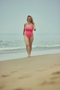 Portrait of young woman standing at beach